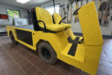 Yellow industrial vehicle with black accents in a workshop setting