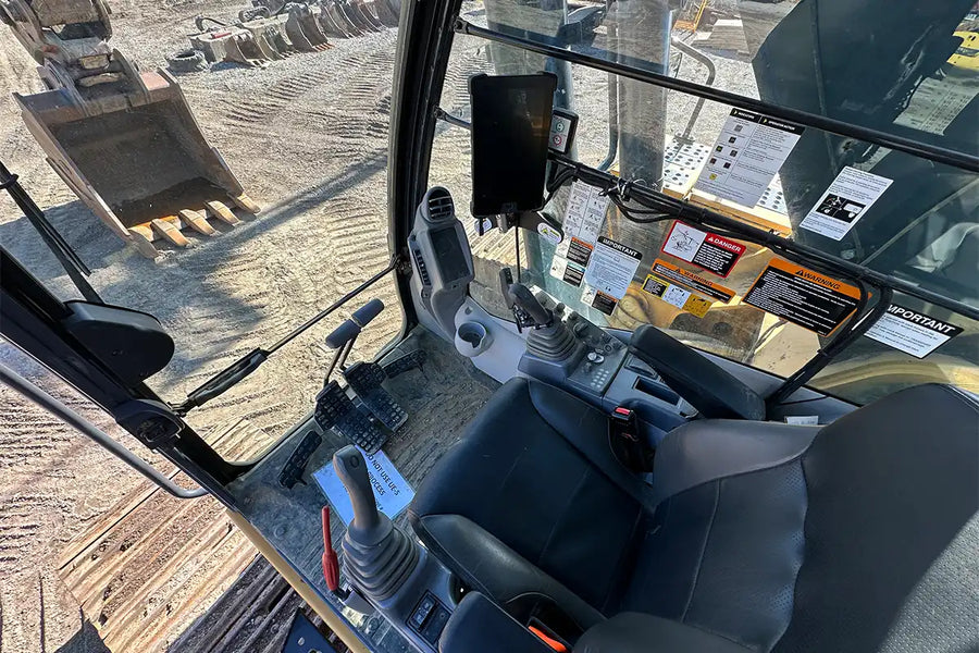 Operator's seat and controls inside a construction vehicle on a job site
