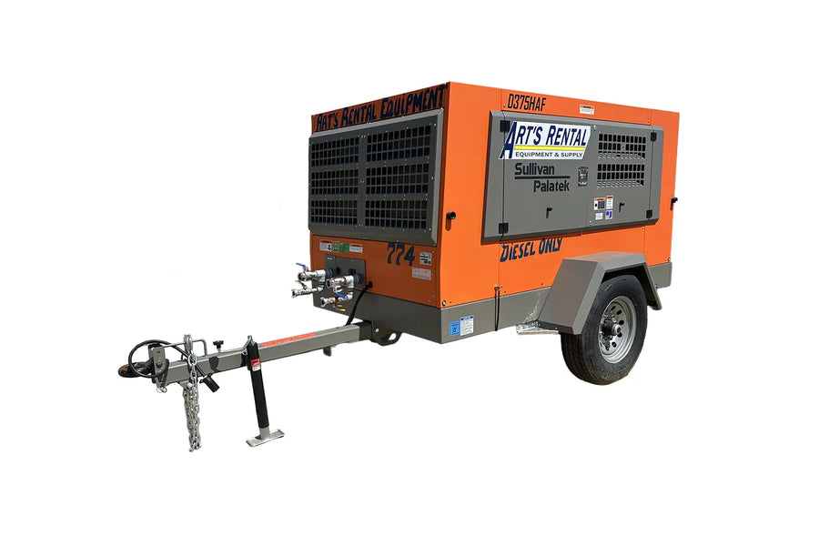An orange diesel air compressor on a trailer.